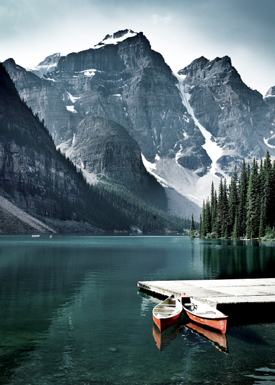  – Fotografia jazera s malým mólom a dvoma kanoe s horami v pozadí