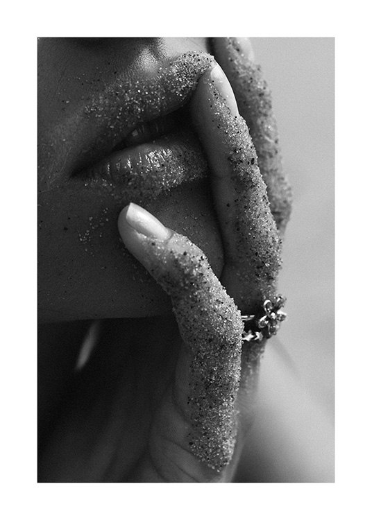  – Čiernobiela fotografia s detailným záberom na ženské pery a prsty od piesku