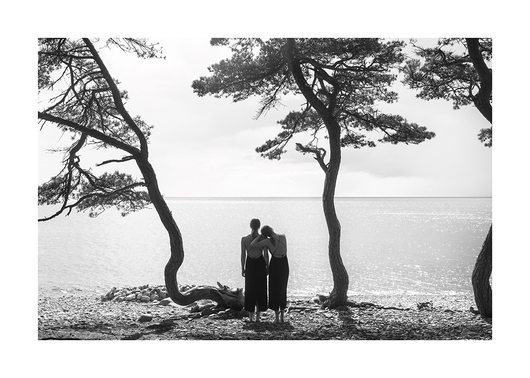  – Čiernobiela fotografia žien dívajúcich sa na vodu z pláže so stromami